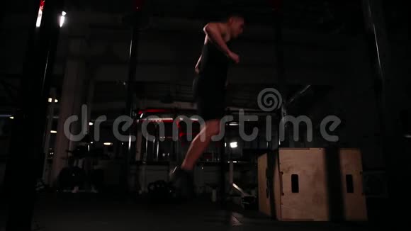 一个人在一个健身房跳一棵桦树在一个木立方体上跳然后立即表演把酒吧提升到二头肌视频的预览图