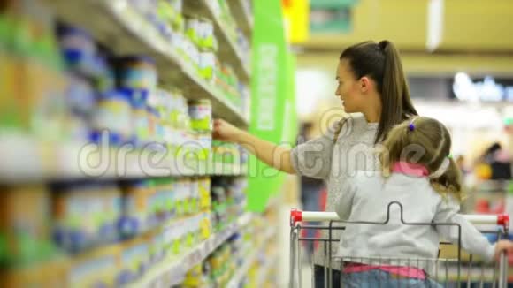 家庭购物概念微笑的女人和女孩在食品店挑选产品的肖像视频的预览图
