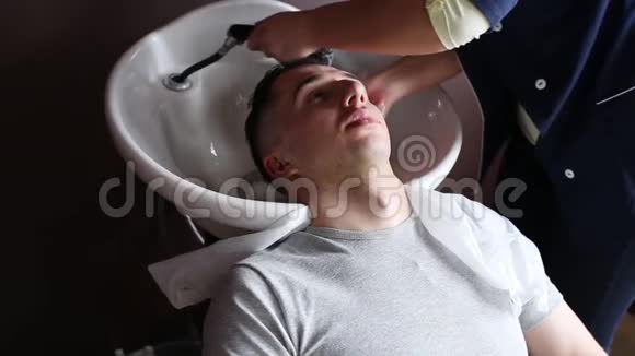 理发师给一个男性客户的头做清洁视频的预览图