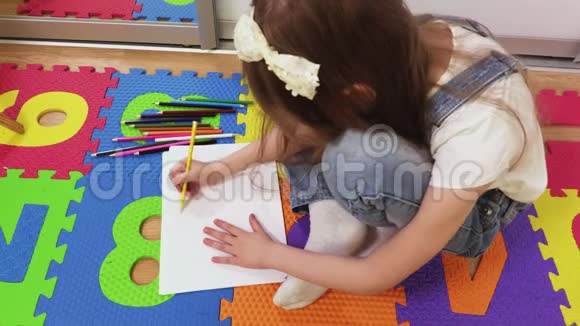 小女孩坐在地板上画画视频的预览图