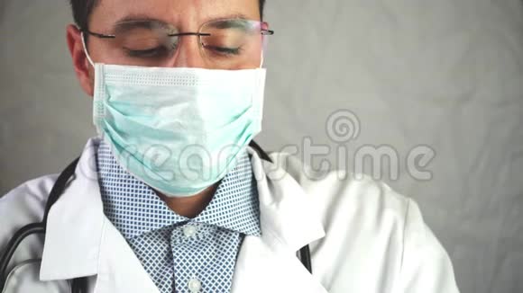 实验室工作中一名男医生拿着一个试管戴着医用口罩和眼镜从一个蓝色橡胶试管中取出一份分析报告视频的预览图