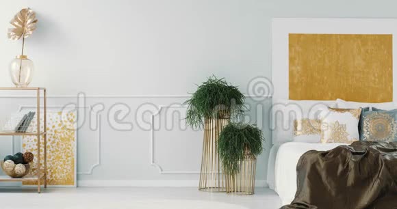 白色和灰色枕头与金色图案的床在优雅的卧室内部与金色绘画视频的预览图