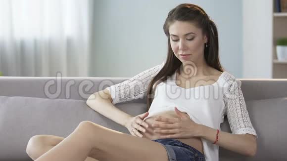 未来的母亲摸着肚子看着镜头微笑诊所广告视频的预览图