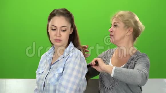 女人在梳理她的女儿绿色屏幕视频的预览图
