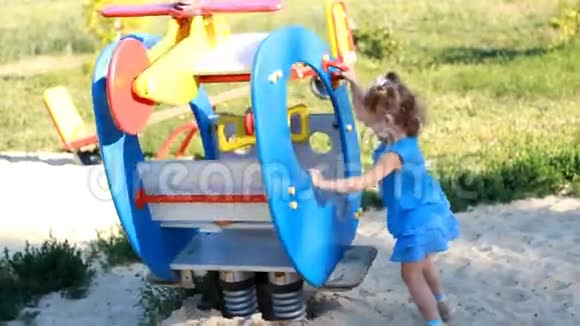 小女孩正在游乐园里骑旋转木马直升机婴儿在操场上玩耍视频的预览图