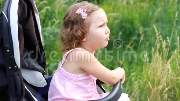 悲伤的孩子坐在婴儿车里等待她的母亲不满和冒犯孩子视频的预览图