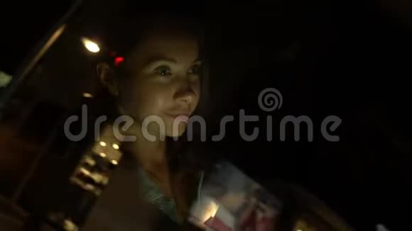 晚上坐在车里用手机的年轻女子视频的预览图