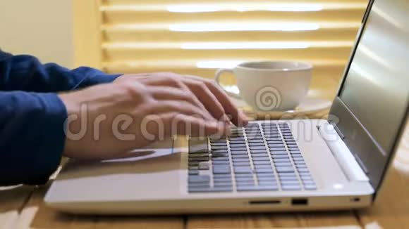 手提键盘使用笔记本电脑跟踪垫滚动网站的人的特写镜头视频的预览图