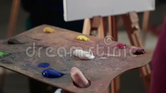 女人用于混合油漆的调色板小组学习画油视频的预览图