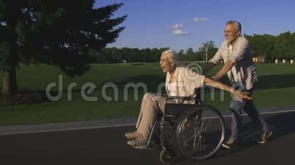 年纪大的男人在轮椅上推着妻子跑步视频的预览图