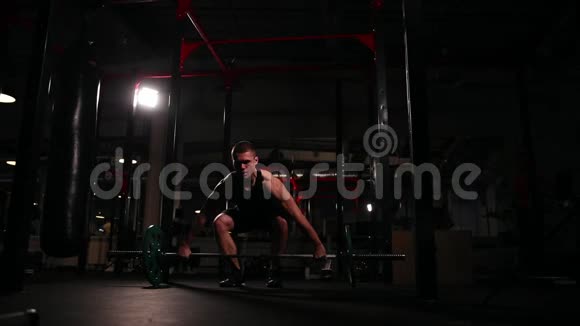 一个穿着黑色运动服的人在健身房里为一个沉重的脱离一个混蛋做运动视频的预览图