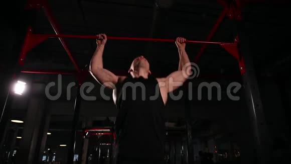 动态运动的镜头一个穿着黑色运动服的男人正在拉杠然后跟着杠去练习视频的预览图