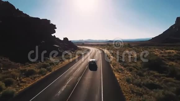 无人机照相机跟随小型货车左转在沙漠公路道路之间惊人的开放空间和山脉视频的预览图