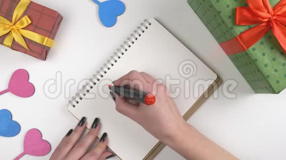 情人节插图女人手在笔记本上写着做我的情人节礼物视频的预览图