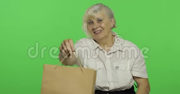 一位带购物袋的老妇人购物呈现铬键视频的预览图