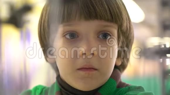 教育童年情感表达和人的概念男孩看着机器里的弹珠这反映了他的视频的预览图