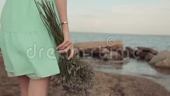 特写慢动作一个女孩带着一束花在海滨散步视频的预览图
