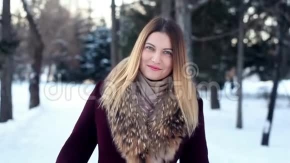 一个美丽的女孩在一片冬林的背景下转过身视频的预览图