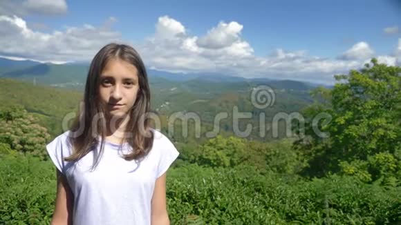 肖像美丽的山景和蓝天背景下迷人的少女视频的预览图