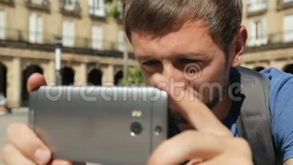旅行者用手机特写镜头拍摄城市广场全景视频的预览图