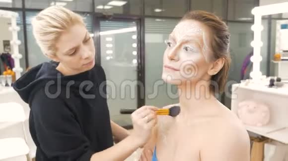 专业化妆师做模特的化妆涂上一层特殊的油漆筹备工作视频的预览图