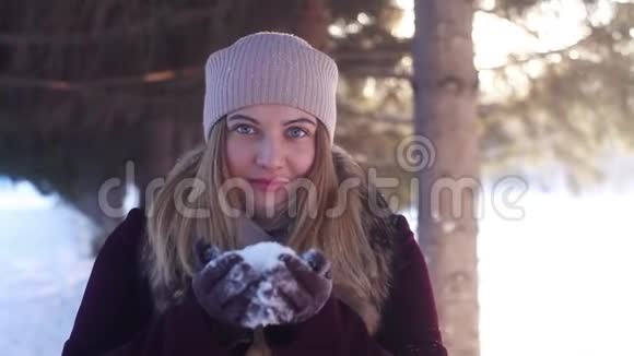 阳光明媚的冬天年轻快乐的女孩在露天吹雪视频的预览图
