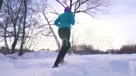 冬天公园的女孩在日落时跑步视频的预览图