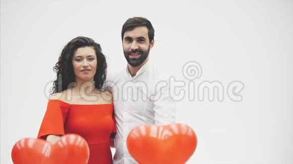 在白色背景下被隔离的美丽浪漫夫妇一位迷人的年轻女子漂亮的双手举起气球视频的预览图