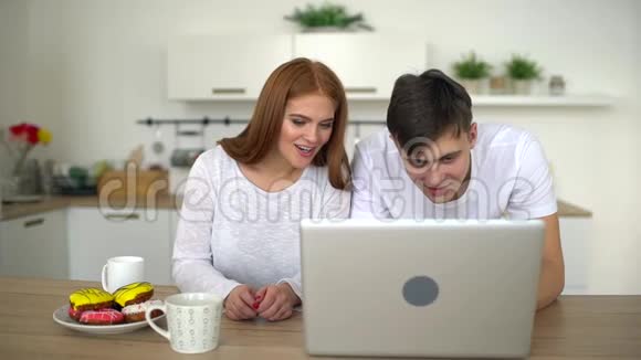 快乐迷人的年轻夫妇在家放松看电视电影或笔记本电脑上的foto慢动作视频的预览图