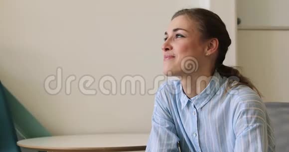 快乐的年轻女子坐在椅子上望着远方视频的预览图