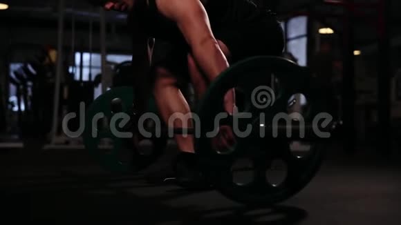 健身房里的一名运动运动员从坐姿上抬起体重高于头部的酒吧特写镜头移动视频的预览图