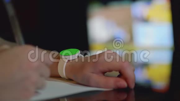 用绿色屏幕聚焦在女孩的左手上的白色手表用女孩的右手去聚焦笔视频的预览图