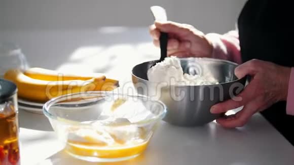 做煎饼一位老妇人在面团中加入面粉视频的预览图