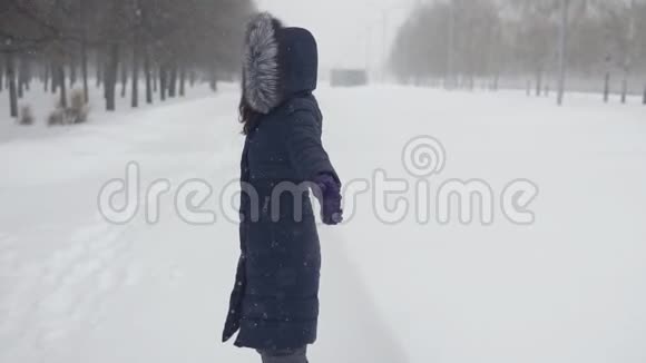 快乐在公园散步一个年轻的女人躺在雪地里视频的预览图