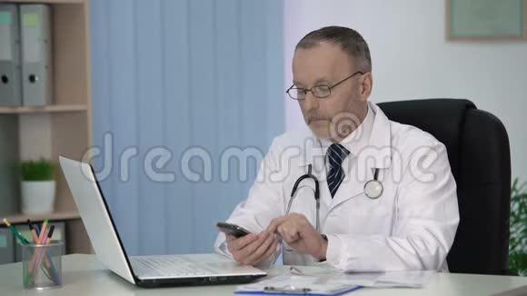 医生在智能手机上阅读医学参考书视频的预览图
