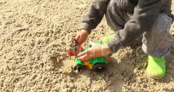 玩拉德的小孩在沙子里玩玩具挖掘机视频的预览图