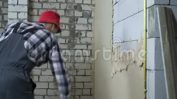 建筑工人在工作时在加气混凝土砌块墙上抹灰泥视频的预览图