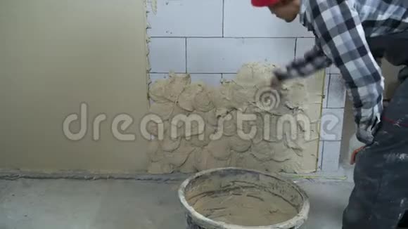 建筑工人在工作时在加气混凝土砌块墙上抹灰泥视频的预览图