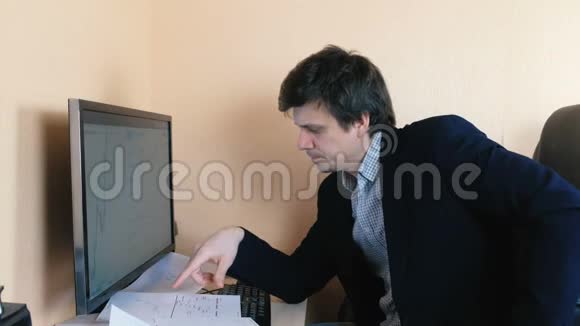 年轻人正在计算机后面努力比较图形视频的预览图