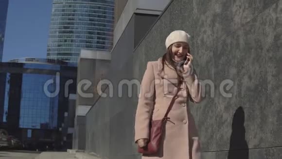 穿着外套的女人去市中心打电话视频的预览图