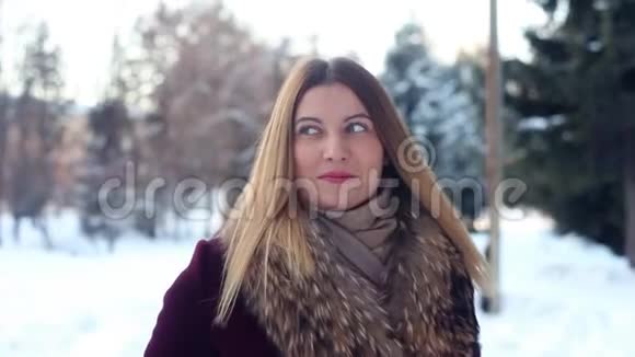 特写镜头美丽时尚的女孩在冬天的公园散步心情很好视频的预览图