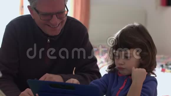 千禧一代的女儿在平板电脑上玩视频的预览图