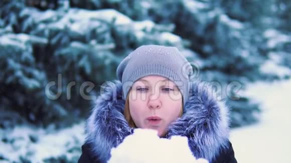 女孩从她的手里吹雪冬天的射击寒冷视频的预览图