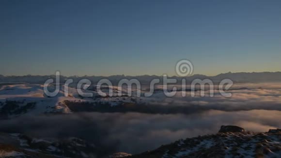 从后面看一个孤独的人站在高高的山上看着夕阳和夕阳的地平线视频的预览图