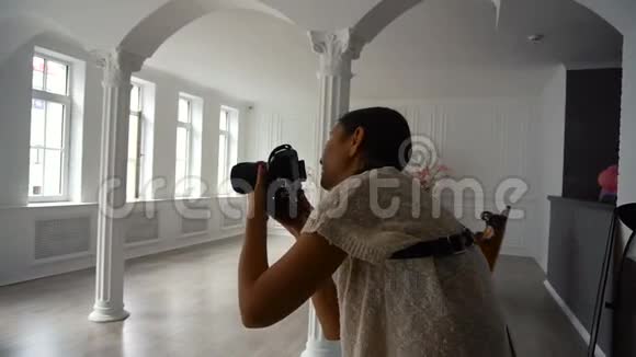 年轻迷人的女摄影师在室内拍摄dslr相机室内有Grunge室内室视频的预览图