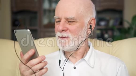 现代老人用智能手机听音乐退休的梅洛曼跳舞视频的预览图