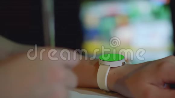 用绿色屏幕聚焦在女孩的左手上的白色手表用女孩的右手去聚焦笔视频的预览图