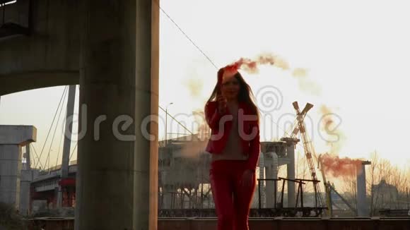穿着红色服装的美女在废弃的桥边跳着红烟视频的预览图