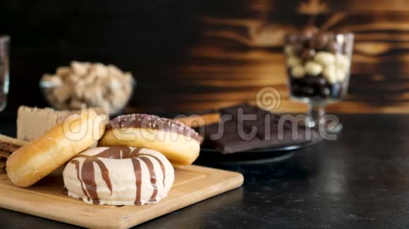 在不同类型的糖果旁边的木板上放三个甜甜圈视频的预览图