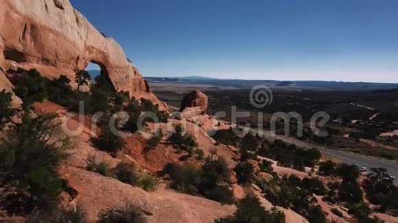 无人机在大岩组附近飞行大洞覆盖着灌木丛游客欣赏着山地沙漠的景色视频的预览图